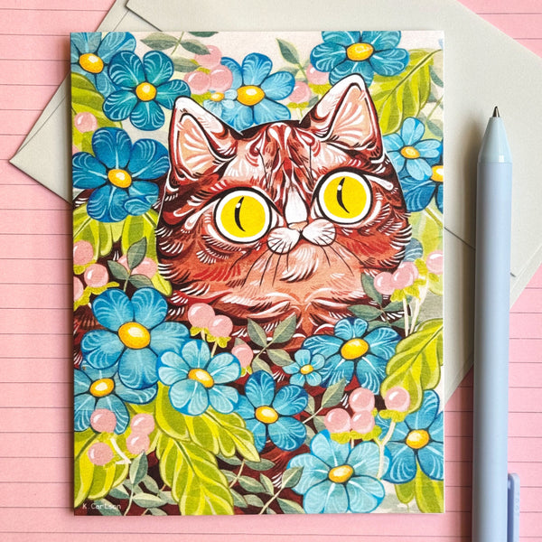 Card with a cat illustration surrounded by flowers on a pink background